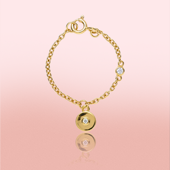 Circular watch charm in 14kt gold and bazel set diamond in center